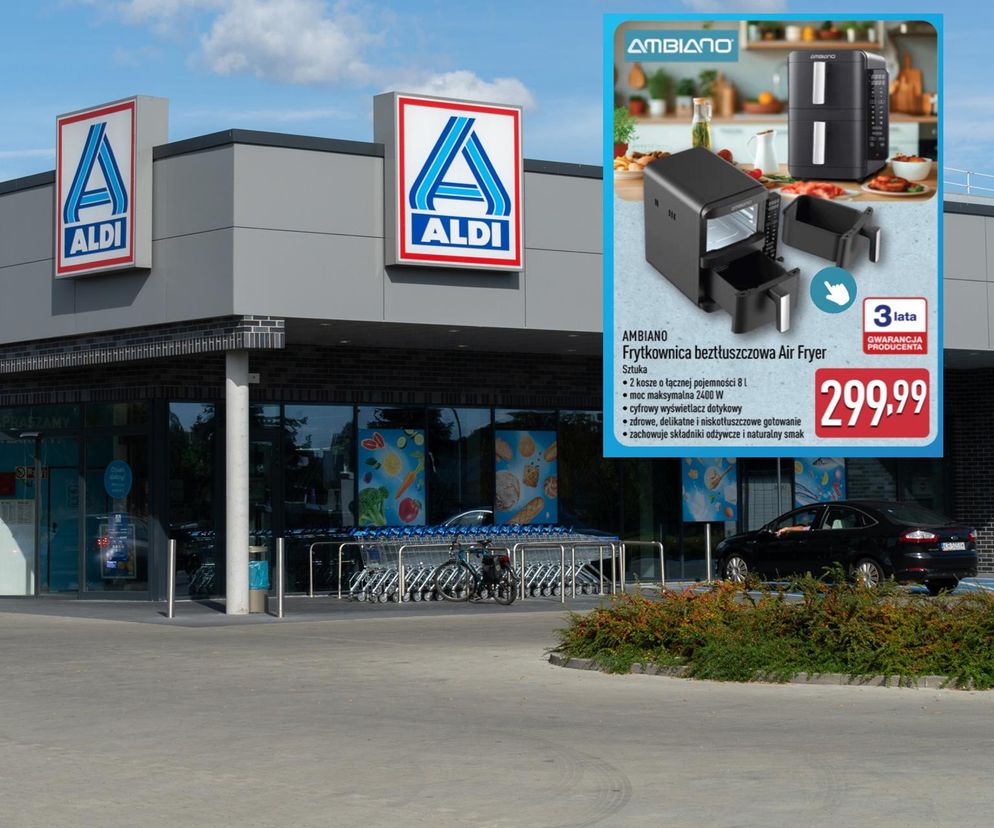 Zewnętrzny widok na sklep ALDI z dwoma logo i rzędem wózków sklepowych. Na zdjęciu promocyjnym z Super Biznes w prawym górnym rogu widać frytkownicę beztłuszczową AMBIANO Air Fryer z dwoma koszami, gwarancją 3 lata i ceną 299,99 zł. Urządzenie pozwala na zdrowe gotowanie i redukcję tłuszczu.
