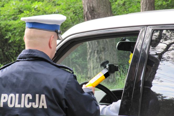 Policjant przeprowadza badanie alkomatem