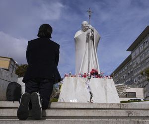 Świeczki, kartki z życzeniami, balony w kształcie serca, kwiaty składane są pod pomnikiem Jana Pawła II przed rzymską Polikliniką Gemelli