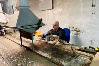 Pan Błażej zajmuje się dmuchaniem bombek od ponad 30 lat, tutaj na stanowisku w fabryce Kadpol