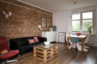Przytulna aranżacja salonu: drewno i ściana z cegieł. Pomysłowy salon z jadalnią
