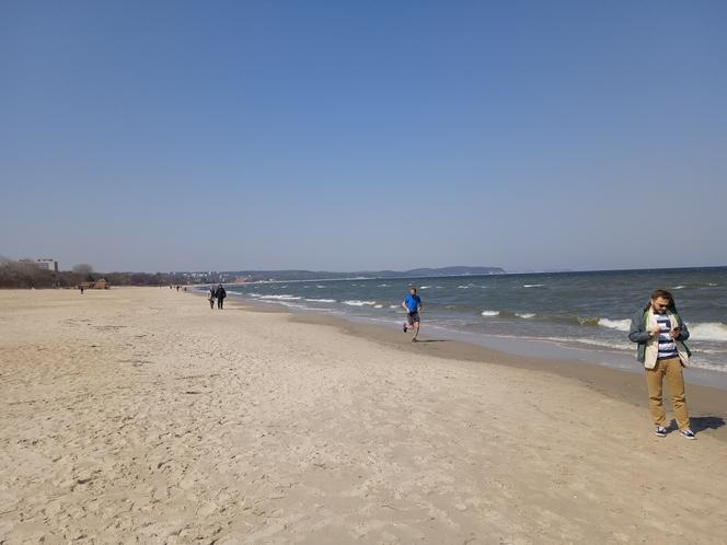 Mieszkańcy korzystają ze słonecznej pogody. Na plaży w Jelitkowie widać już pierwszych spacerowiczów!