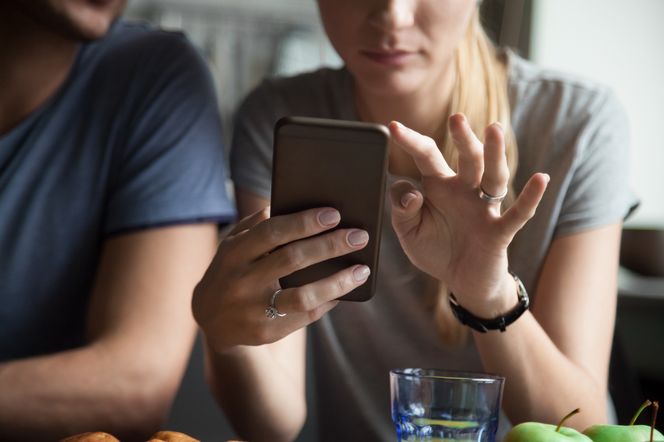 Zbliżenie na kobietę, która trzyma w dłoni smartfon