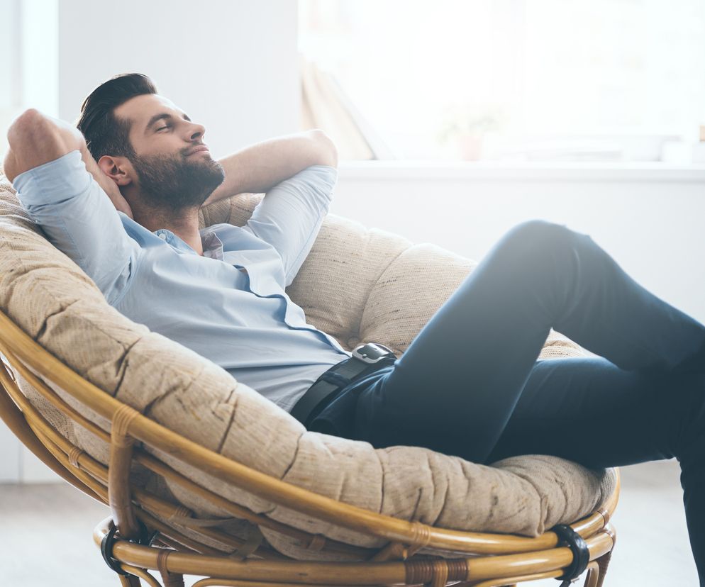 Zrelaksowany mężczyzna siedzi na fotelu