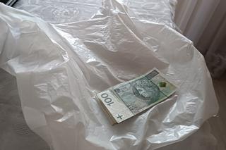 Uwierzyła oszustom, straciła oszczędności życia. Seniorka spakowała pieniądze w reklamówkę i wywiesiła je za drzwiami mieszkania