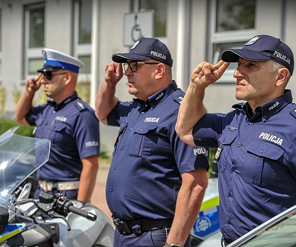 Policjanci salutują w czasie uroczystości przed komendą policji