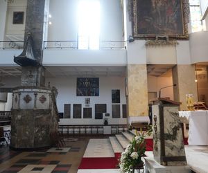Wnętrze kościoła św. Stanisława Kostki, przed którym znajduje się nagrobek księdza