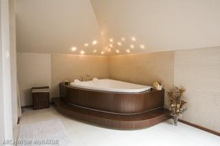 Aranżacja łazienki z zabudowaną wanną i halogenowym oświetleniem