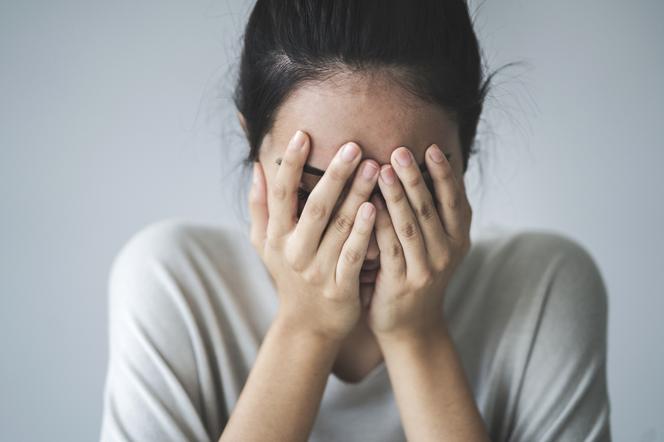 Zestresowana kobieta trzyma twarz w dłoniach