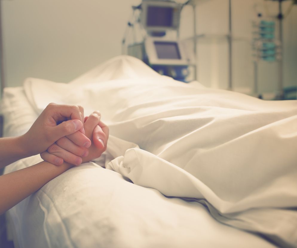 Bliska osoba trzyma chorego leżącego w szpitalu