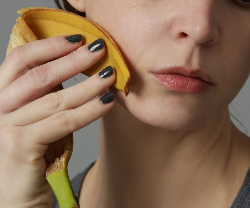 Kobieta pociera twarz skórką od banana