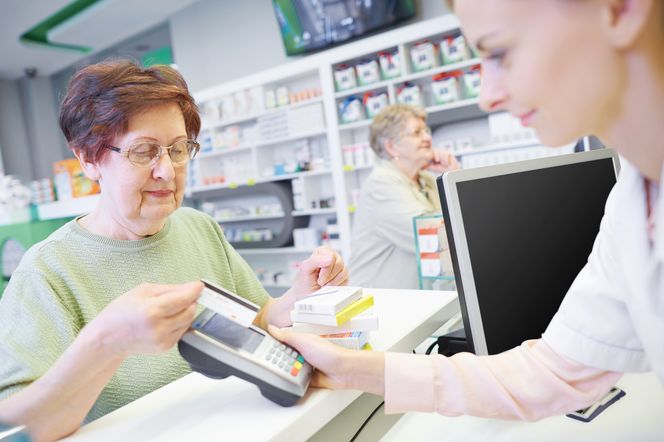 Seniorka płaci za leki w aptece