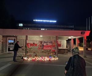 Mieszkańcy zapalają znicze i składają kwiaty przed bramą szpitala MON przy Szaserów w Warszawie, gdzie zmarł żołnierz raniony na granicy z Białorusią
