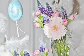 dekoracja stołu na Wielkanoc z kilku małych bukiecików iosennych kwiatów