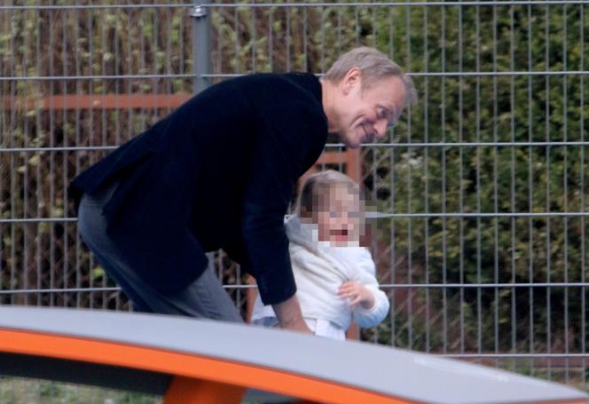 Donald Tusk z wnuczka na placu zabaw