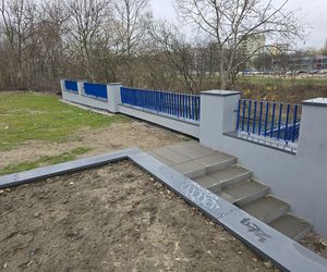 Kładka, a przy niej schody, które prowadzą na... trawę