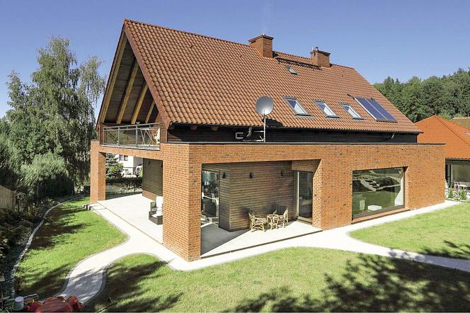 Klasyczny falisty wzór z brązowych dachówek znakomicie współgra z nowoczesną bryłą domu