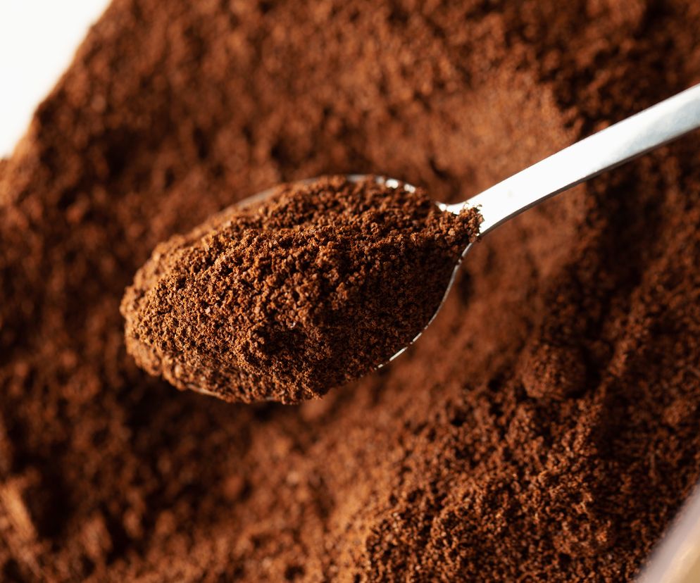 Zbliżenie na łyżeczkę wypełnioną fusami z kawy 