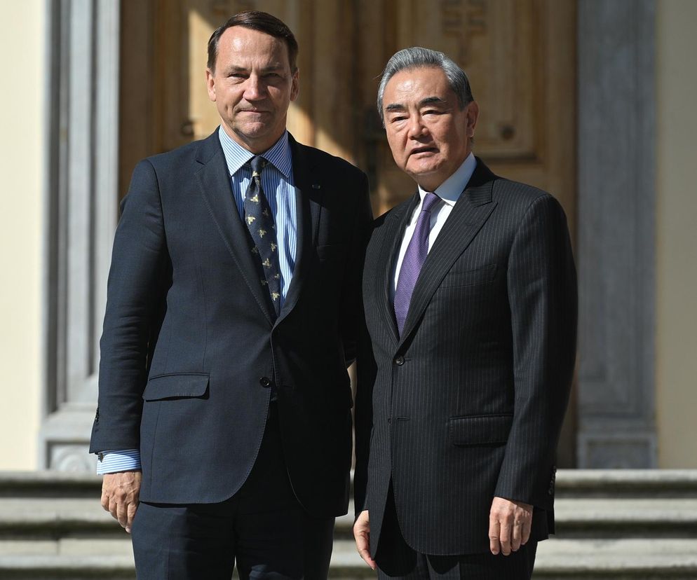 Radosław Sikorski, minister spraw zagranicznych Polski, oraz Wang Yi, szef MSZ Chin, stoją obok siebie w garniturach, podczas spotkania w Helenowie, omawiając kwestie handlowe i sytuację na Ukrainie. Więcej o ich rozmowach na Super Biznes.
