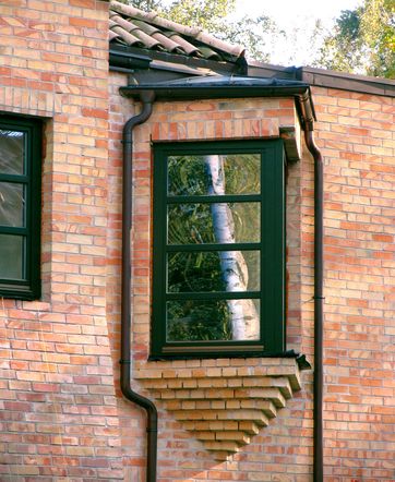 Wykusz we współczesnym domu nawiązujący formą do dawnej architektury - narzuca to w pewnym stopniu zastosowania cegły na elewacji