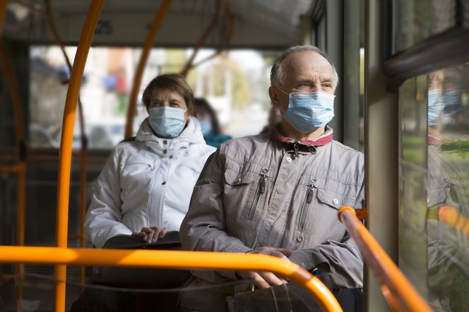 Ludzie w autobusie z maseczkami na twarzy