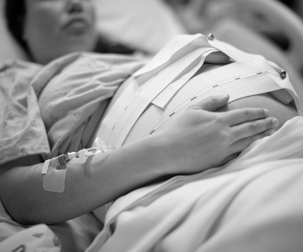 Kobieta w ciąży leżąca w szpitalnym łóżku 