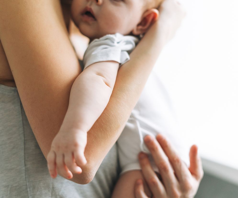 Młoda mama trzymająca dziecko na rękach. 