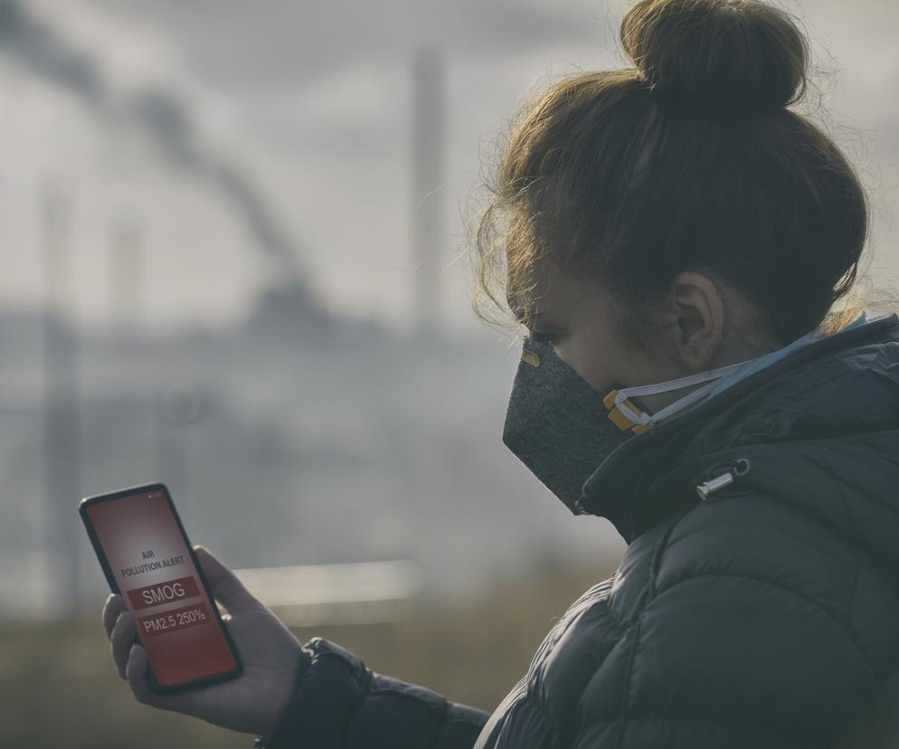 Kobieta mierzy stężenie smogu w powietrzu