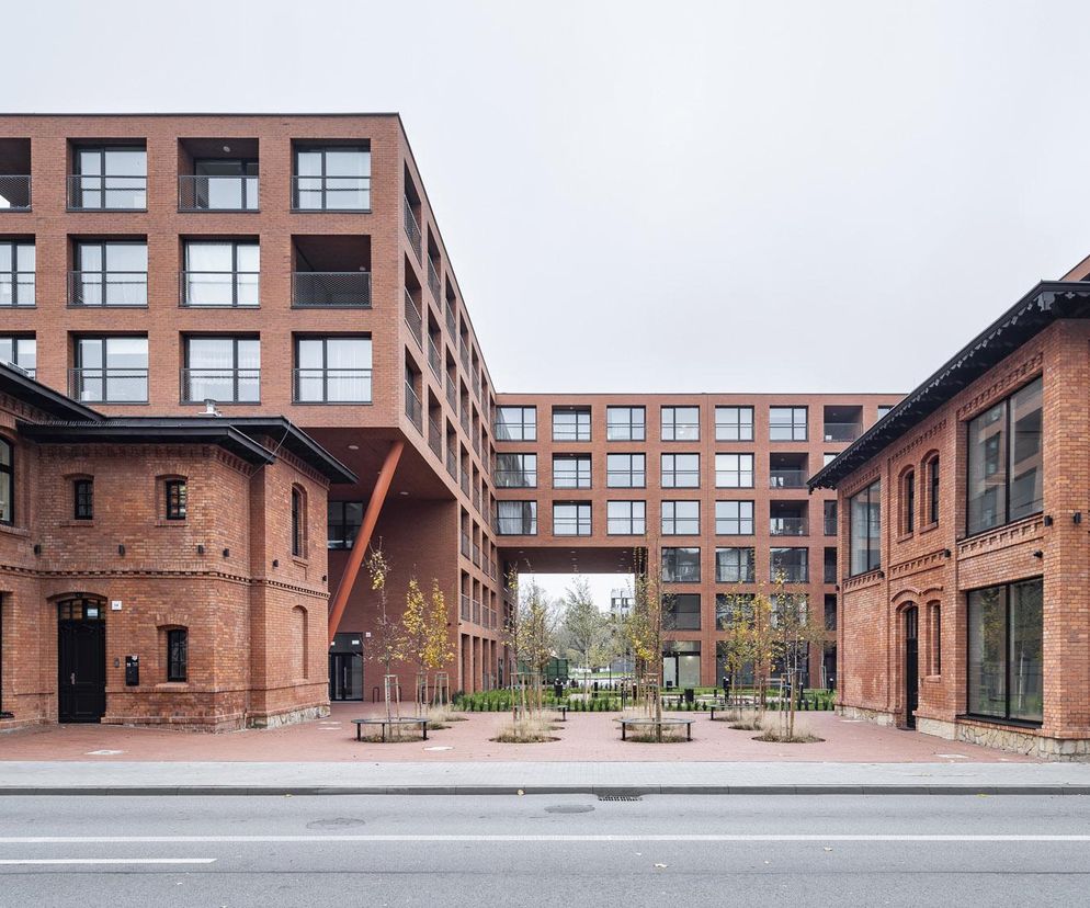 Zespół zabudowy wielorodzinnej Ajnfart w Rybniku, z ceglanymi elewacjami i nowoczesnymi przeszkleniami, otwierający się na słoneczny dziedziniec. Obiekt autorstwa SLAS architekci, biorący udział w konkursie Życie w Architekturze 2025, o którym przeczytasz na Architektura Murator Plus.