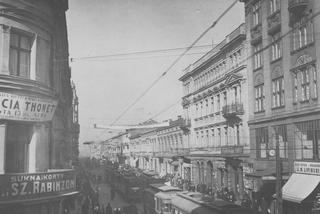 Fragment ulicy Piotrkowskiej. Na budynkach widoczne szyldy reklamowe, na ulicy jadące tramwaje, lata: 1920-1928
