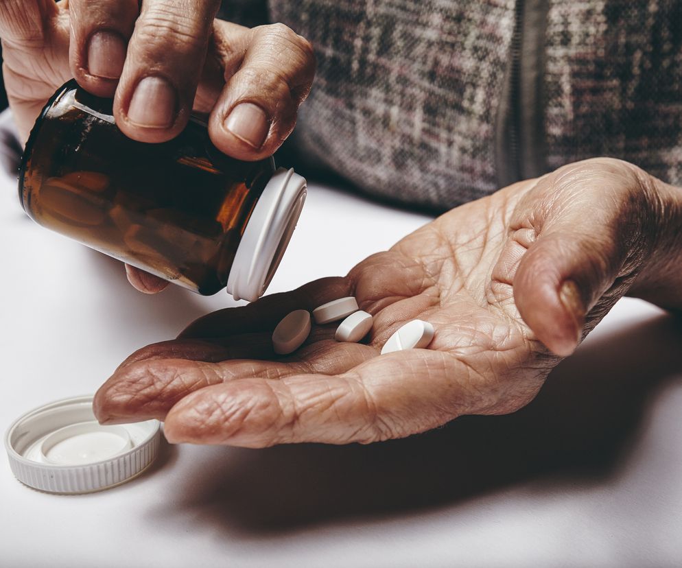 Starszy mężczyzna zażywa tabletki 