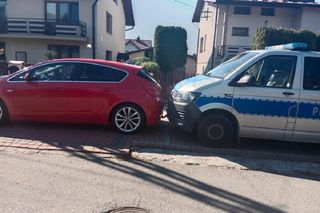 Opel huknął w znak, a później uderzył w radiowóz. Kierowca nie zaciągnął hamulca