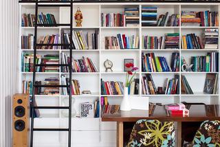 Drabina na kółkach przy wysokich półkach na książki