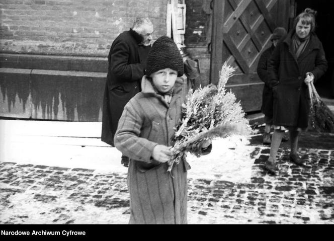 Chłopiec sprzedający palmy wielkanocne przed kościołem w Krakowie (1931)