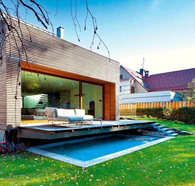 Wysoki taras przy domu. Niczym pomost zawieszony nad basenem ogrodowym