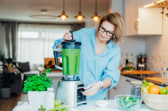 Kobieta robi koktajl z zielonych warzyw