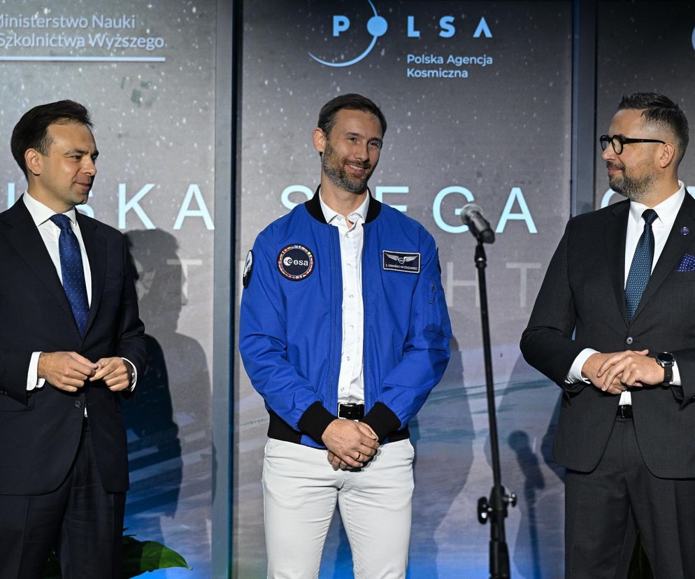 Sławosz Uznański-Wiśniewski w niebieskiej kurtce ESA, uśmiechnięty, obok Minister Nauki i Szkolnictwa Wyższego dr Marcin Kulasek i Minister Finansów i Gospodarki Andrzej Domański podczas konferencji IGNIS - Polska sięga gwiazd. Więcej o misji kosmicznej przeczytasz na Super Biznes.