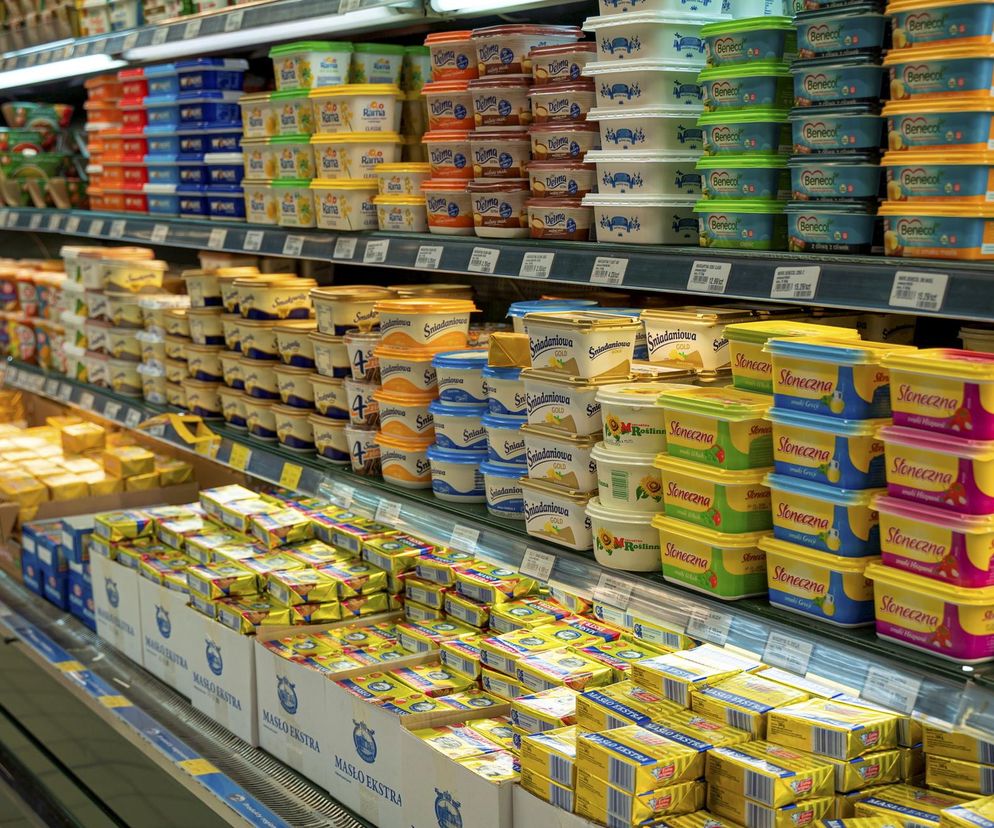 Półki sklepowe uginają się pod ciężarem marek masła.  Promocja w ALDI – masło za 5,99 zł!  Dowiedz się więcej o tej ofercie na Super Biznes.  Zdjęcie przedstawia różnorodne rodzaje i opakowania masła, dostępne w supermarkecie.