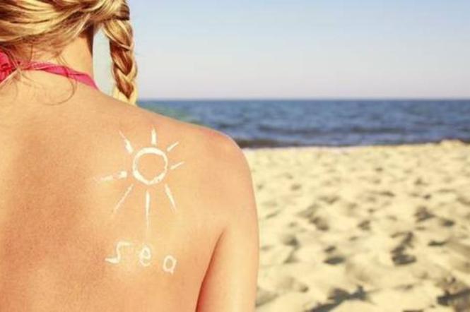 kobieta, plaża, morze, wakacje, opalanie się, krem z filtrem, ochrona przed słońcem