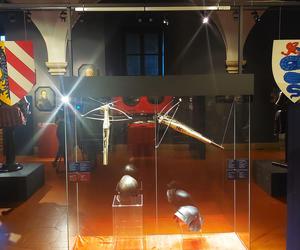 Kusze i hełmy flankowane herbami Norymbergi (z lewej) i Mediolanu (z prawej)