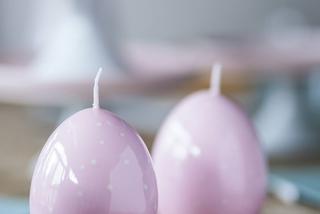 Dekoracja stołu na Wielkanoc z różowych świec w kształcie pisanek