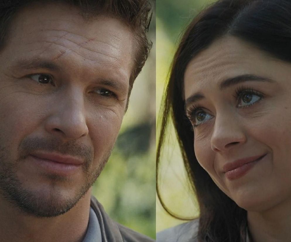 Zbliżenia twarzy Marcina (Mikołaj Roznerski) i Izy (Adriana Kalska) z serialu M jak miłość. Marcin ma delikatny uśmiech, a Iza wyraża ciepłe emocje, w tle widać rozmazaną zieleń. Więcej o ich losach przeczytasz na Super Seriale.