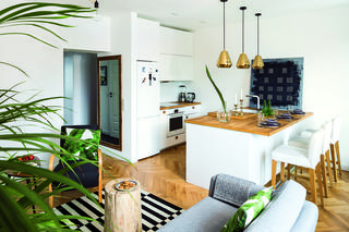 Widok z salonu na kuchnię z wyspą.