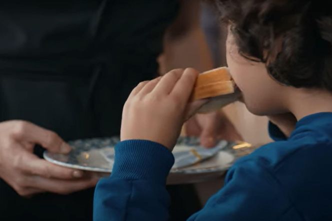 Chłopiec ze smakiem zje chleb, który przyniesie mu Nana 