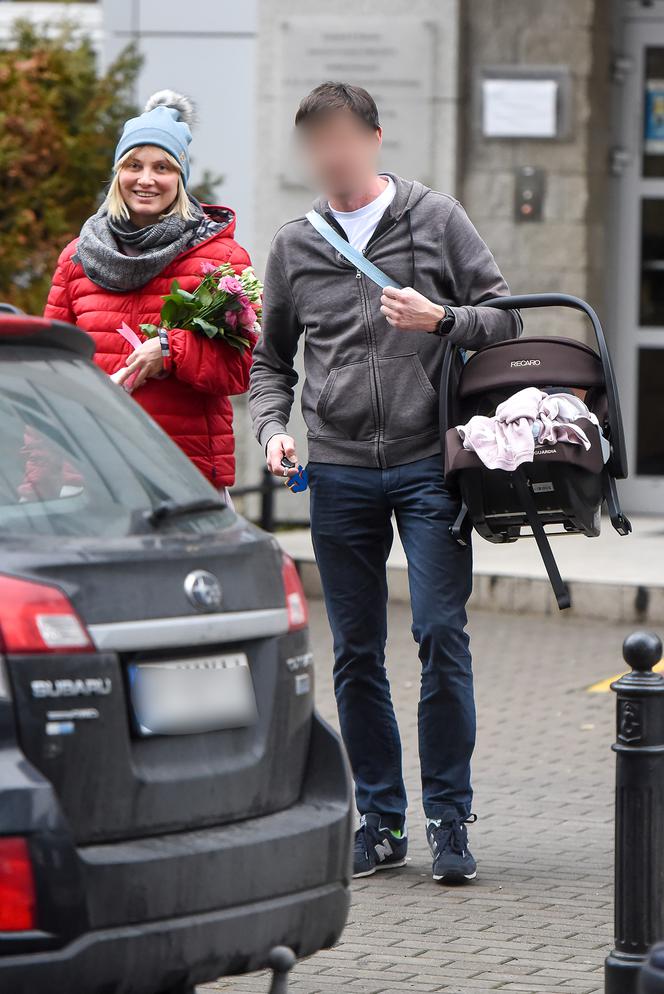 Joanna Moro z mężem i dzieckiem wychodzą po porodzie ze szpitala