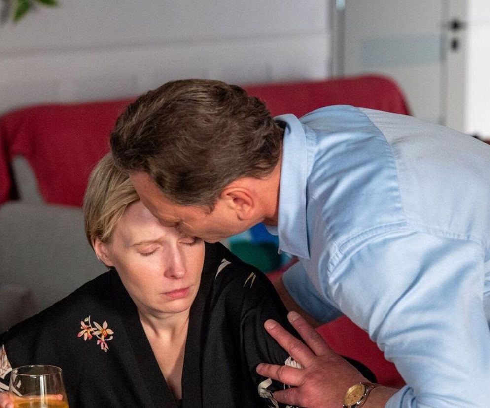 Kobieta w czarnej sukience z zamkniętymi oczami, z kieliszkiem w dłoni, zmartwiona, natomiast mężczyzna w błękitnej koszuli całuje ją w czoło. Emocjonalna scena z serialu Barwy szczęścia, której szczegóły poznasz na Super Seriale. Sonia i Robert mierzą się z trudnymi wyzwaniami w odcinku 3264.