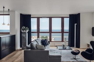 Salon z kuchnią: minimalistyczne serce apartamentu z widokiem na morze