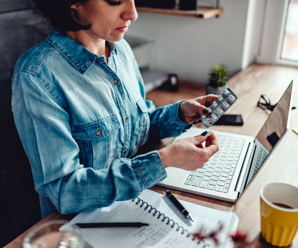 Kobieta przyjmuje leki  w trakcie pracy