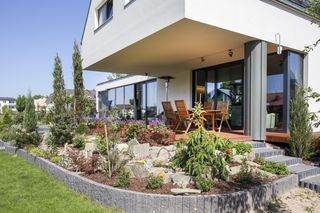 Lewitujące poddasze. Głęboko cofnięta ściana parteru udostępnia szeroką przestrzeń tarasu, którą zacienia wysunięta do przodu ściana szczytowa poddasza