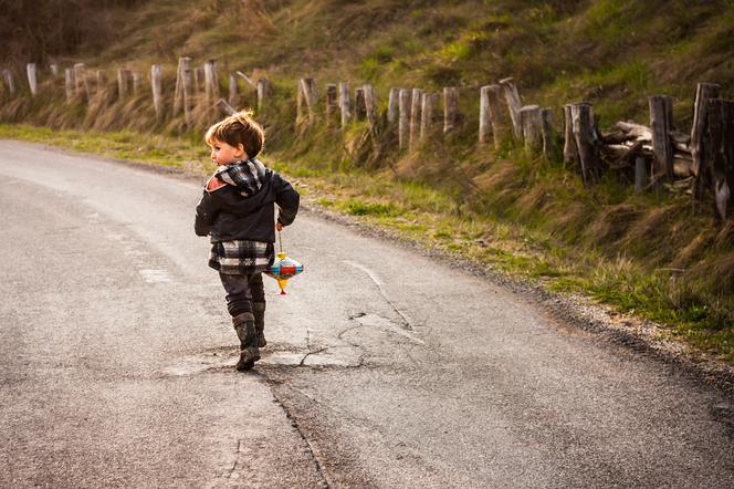 Chłopiec biegnący po drodze